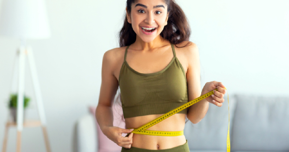 Happy young woman measuring slimmer waistline after weight loss results from Semaglutide Shots in Simi Valley, CA.